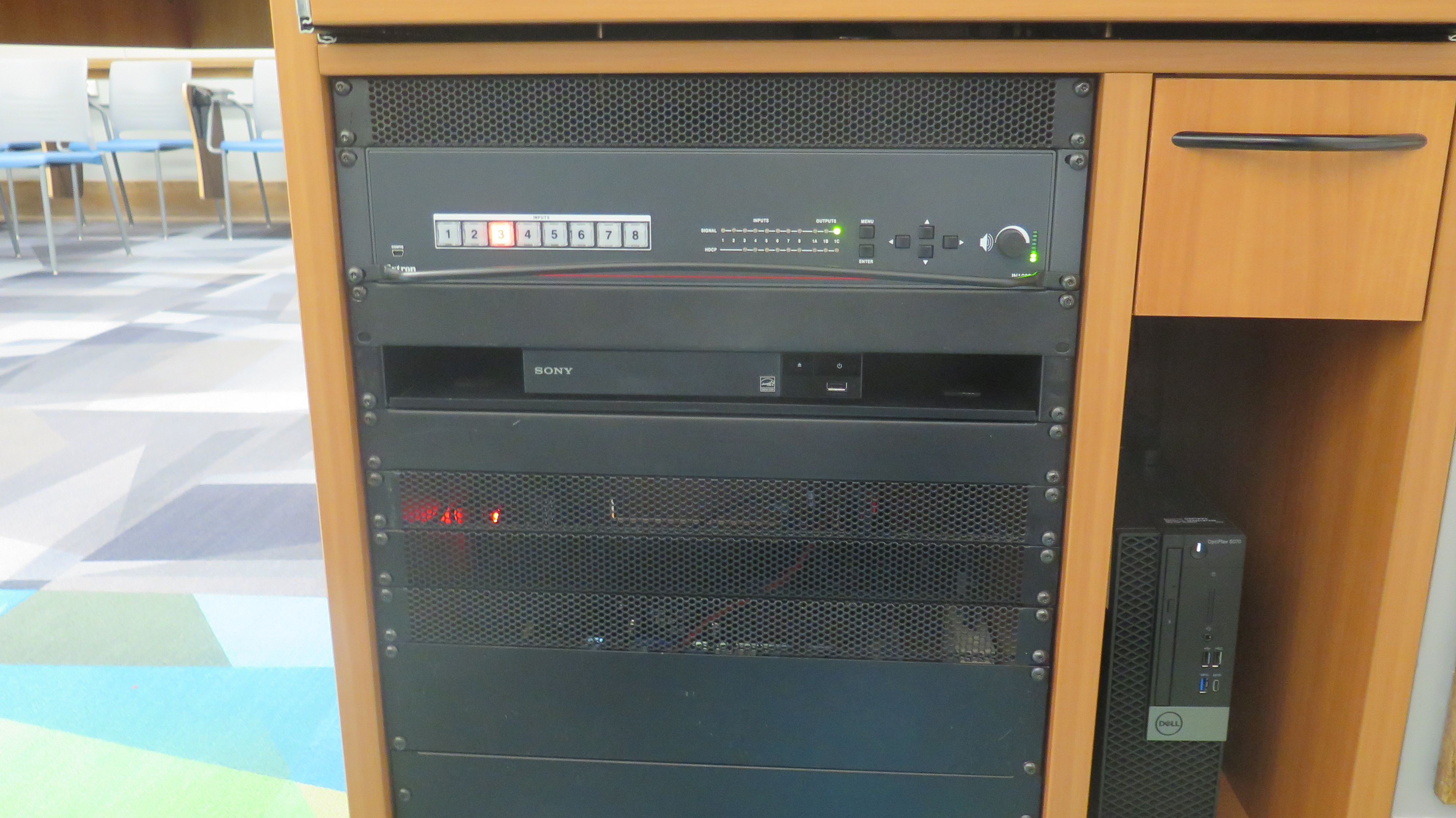 Front of Equipment rack showing AV Switcher. Below that is Blue-Ray/DVD Player. To the right is the compartment with the Dell Computer CPU.