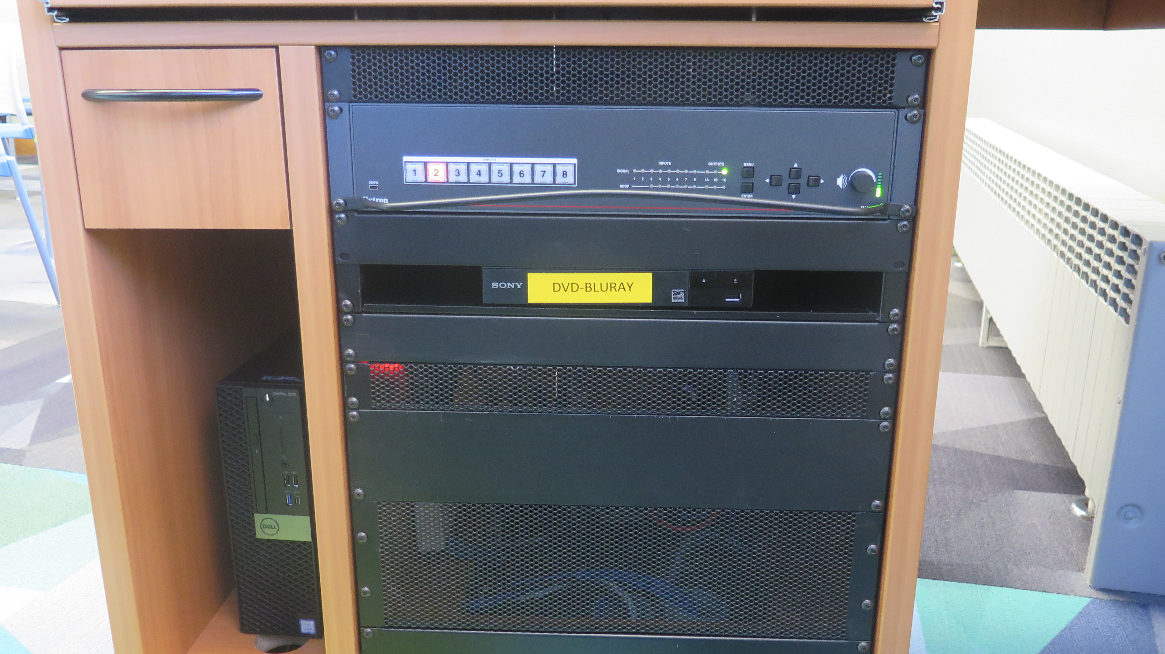 Display rack consists of a AV controller, Blu-Ray/DVD player and Dell Computer CPU.