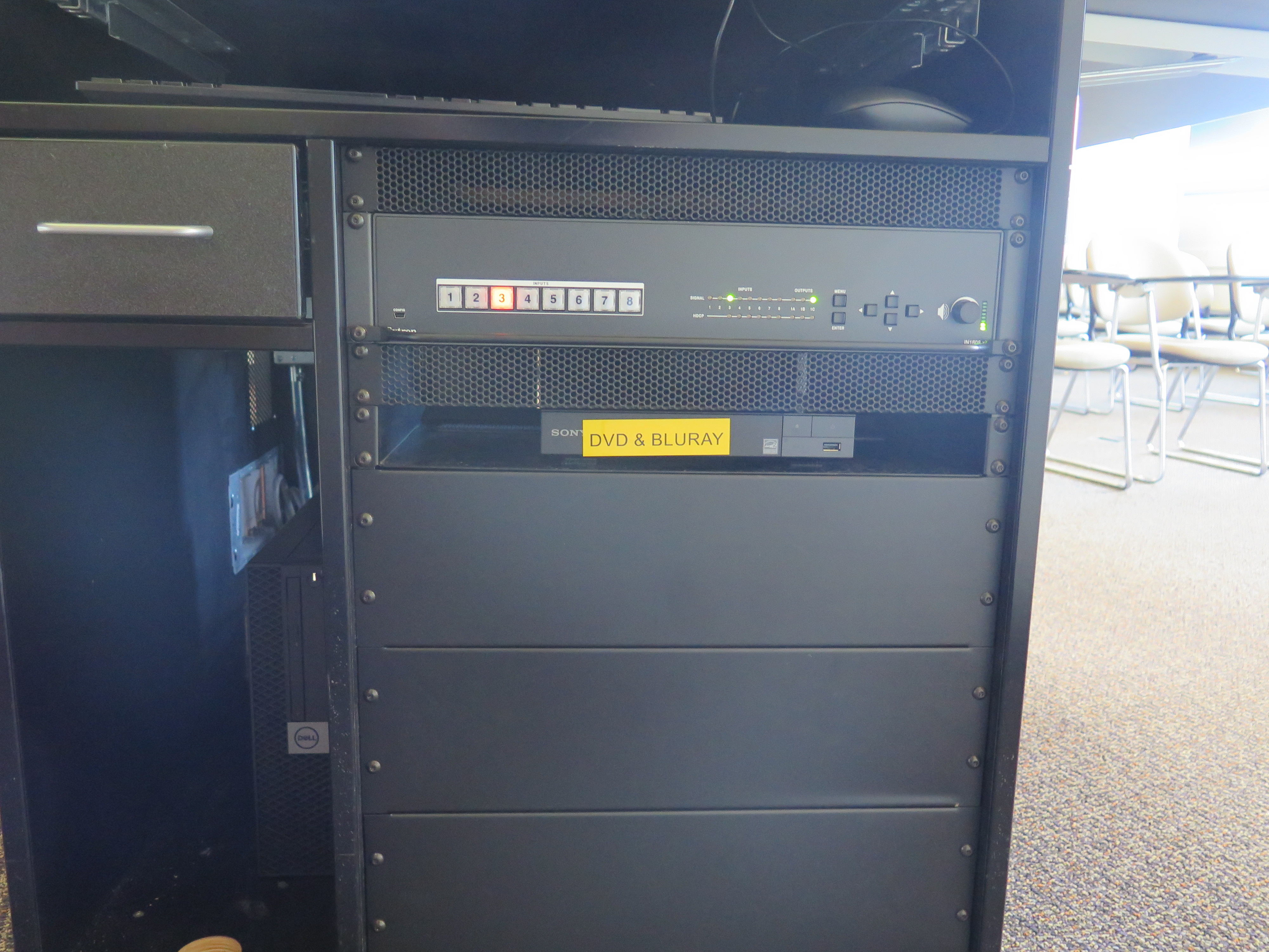 Front of Equipment rack showing AV Switcher. Below that is Blue-Ray/DVD Player. To the left is the compartment with the Dell Computer CPU.