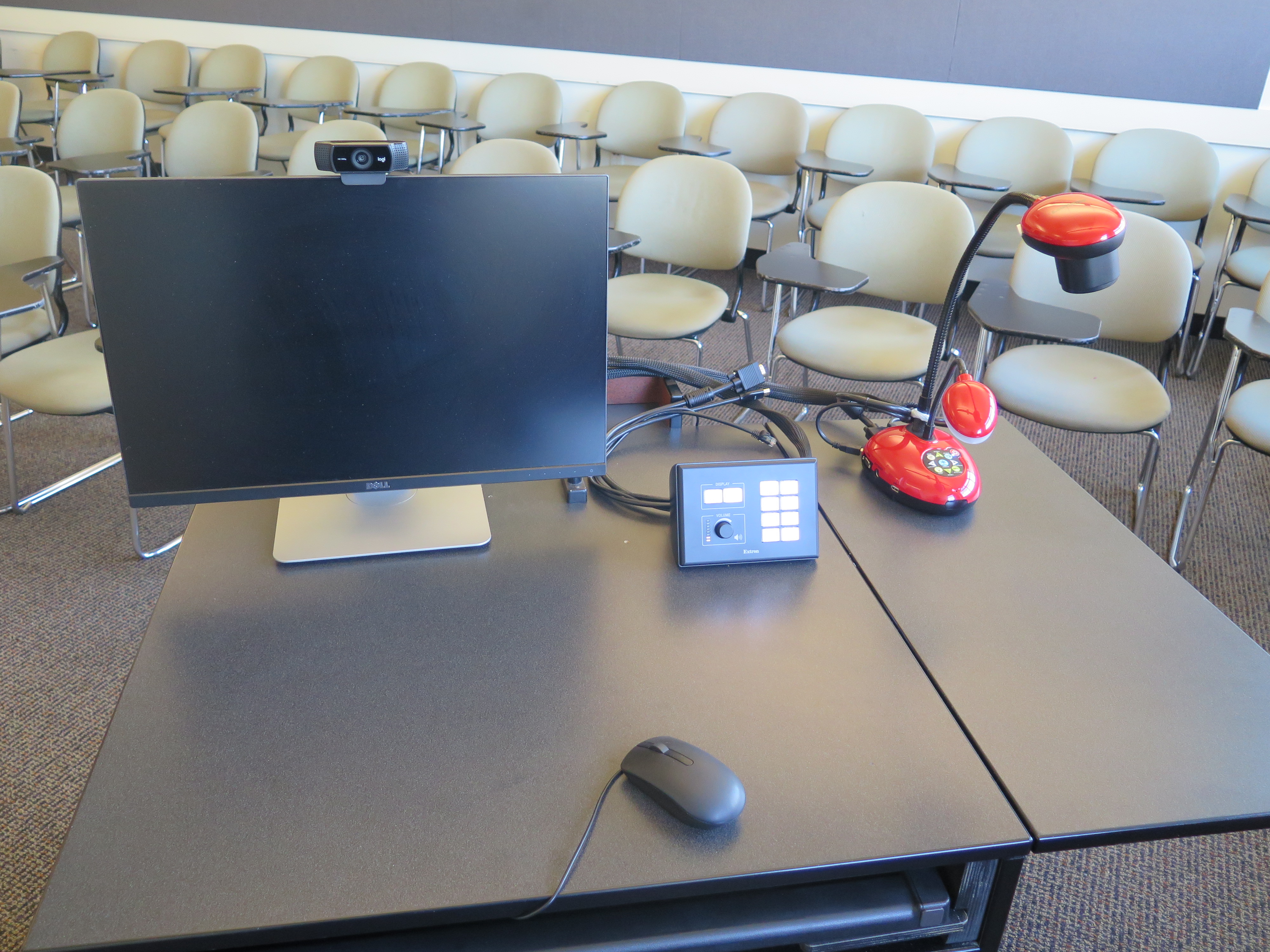 On top of podium is Logitech 920 webcam, Dell computer monitor, AV push button controller, and Lumens Ladybug document camera