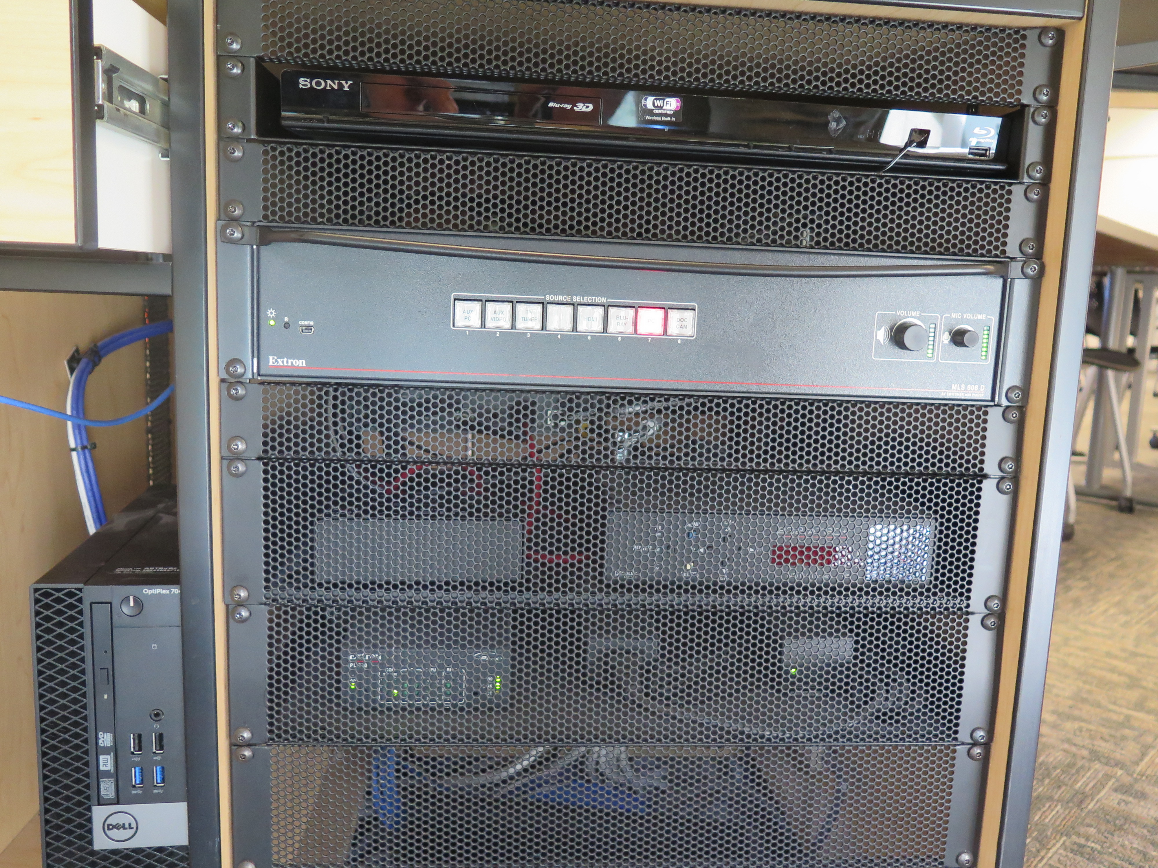 Front of Equipment rack showing a Blue-Ray/DVD Player, below that is the AV Switcher, and to the left is the compartment with the Dell Computer CPU.