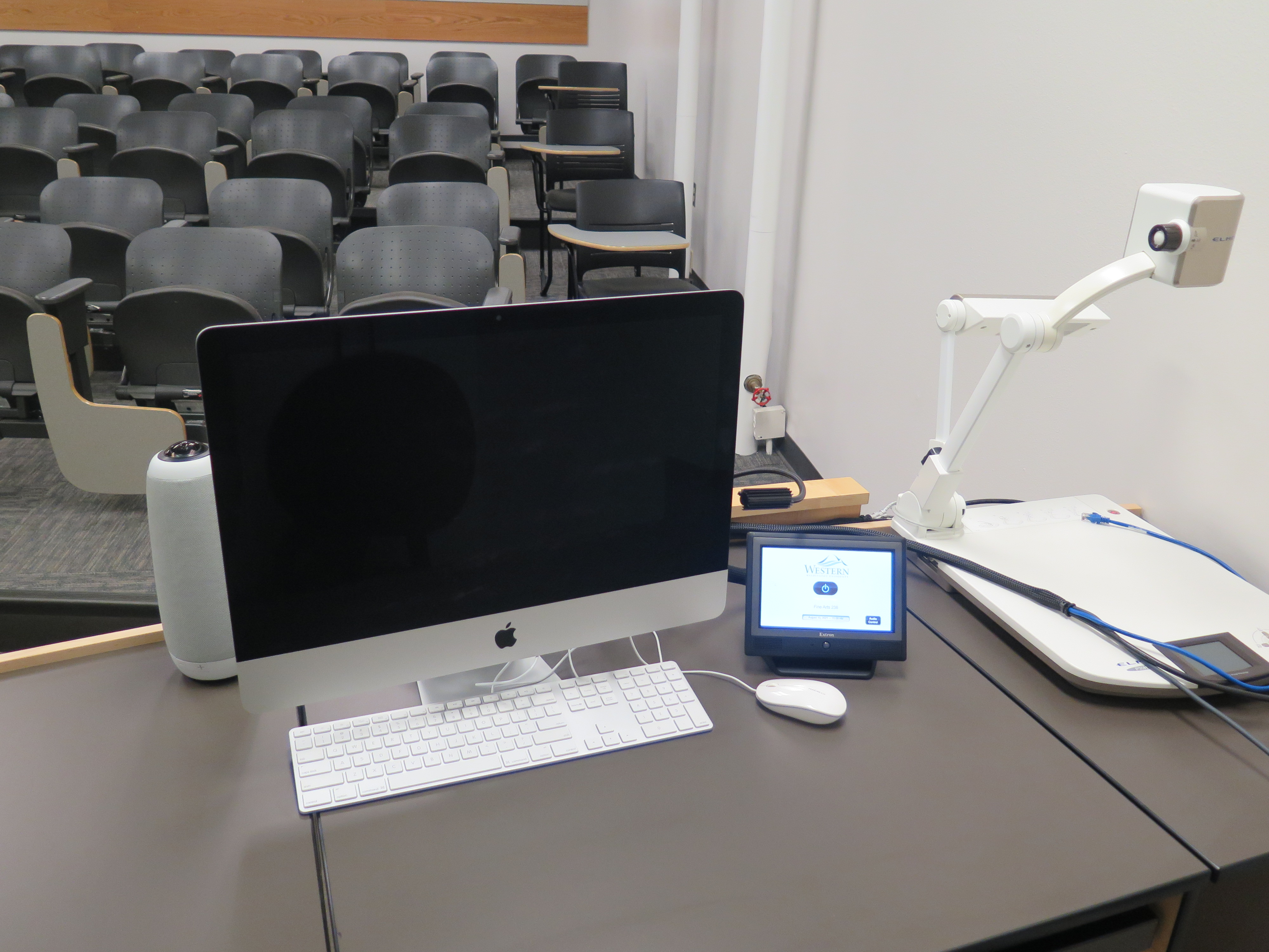 On top of Podium is Owl Webcam, Apple (Mac) Computer Monitor, Touch Screen Controller, and Elmo Document Camera