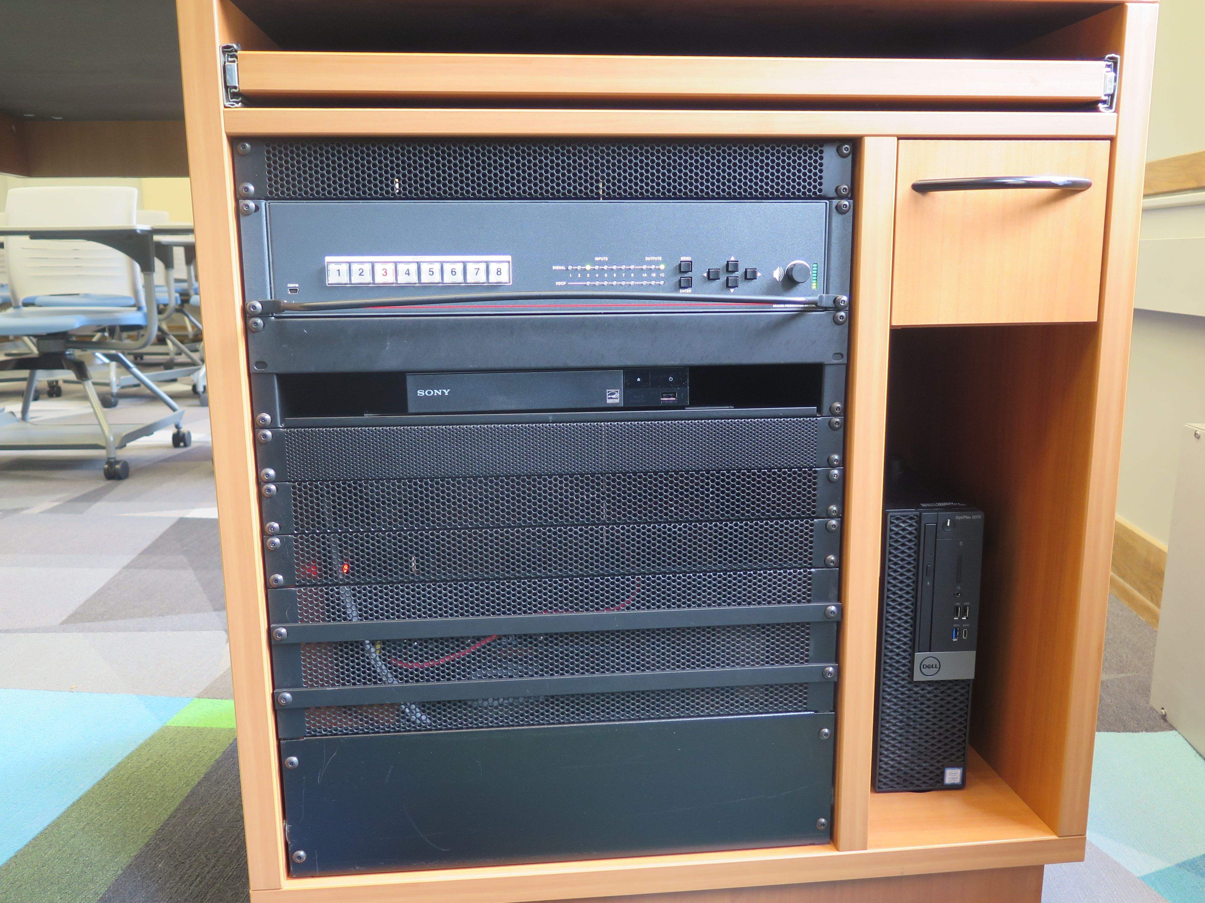 Front of Equipment rack showing a Blue-Ray/DVD Player, below that is the AV Switcher, and to the right is the compartment with the Dell Computer CPU.