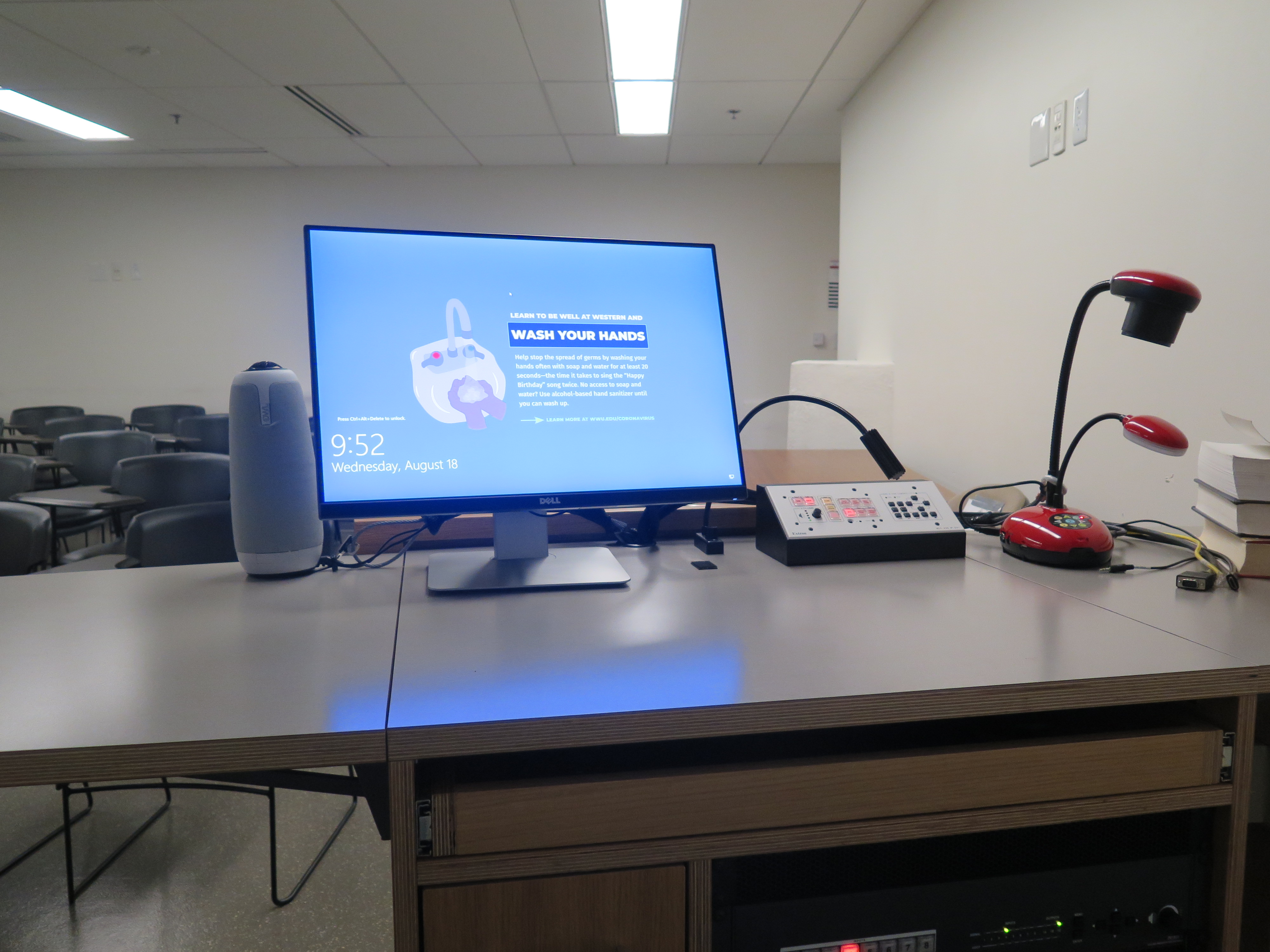 On top of Podium is Owl webcam, Dell Computer Monitor, AV Push Button Controller, and Lumens Ladybug Document Camera.