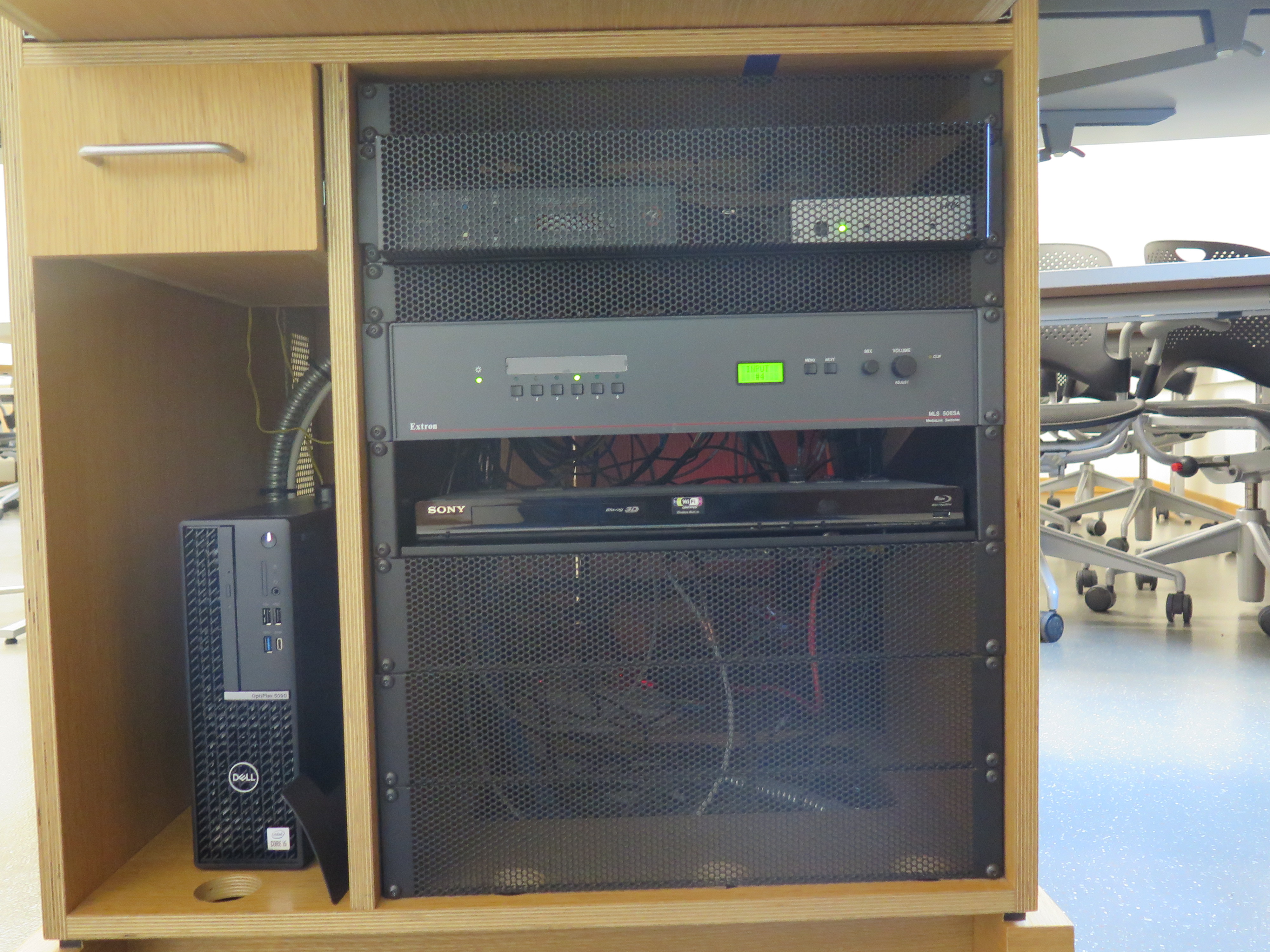 Front of Equipment rack showing AV Switcher. Below that is Blue-Ray/DVD Player. To the left is the compartment with the Dell Computer CPU.