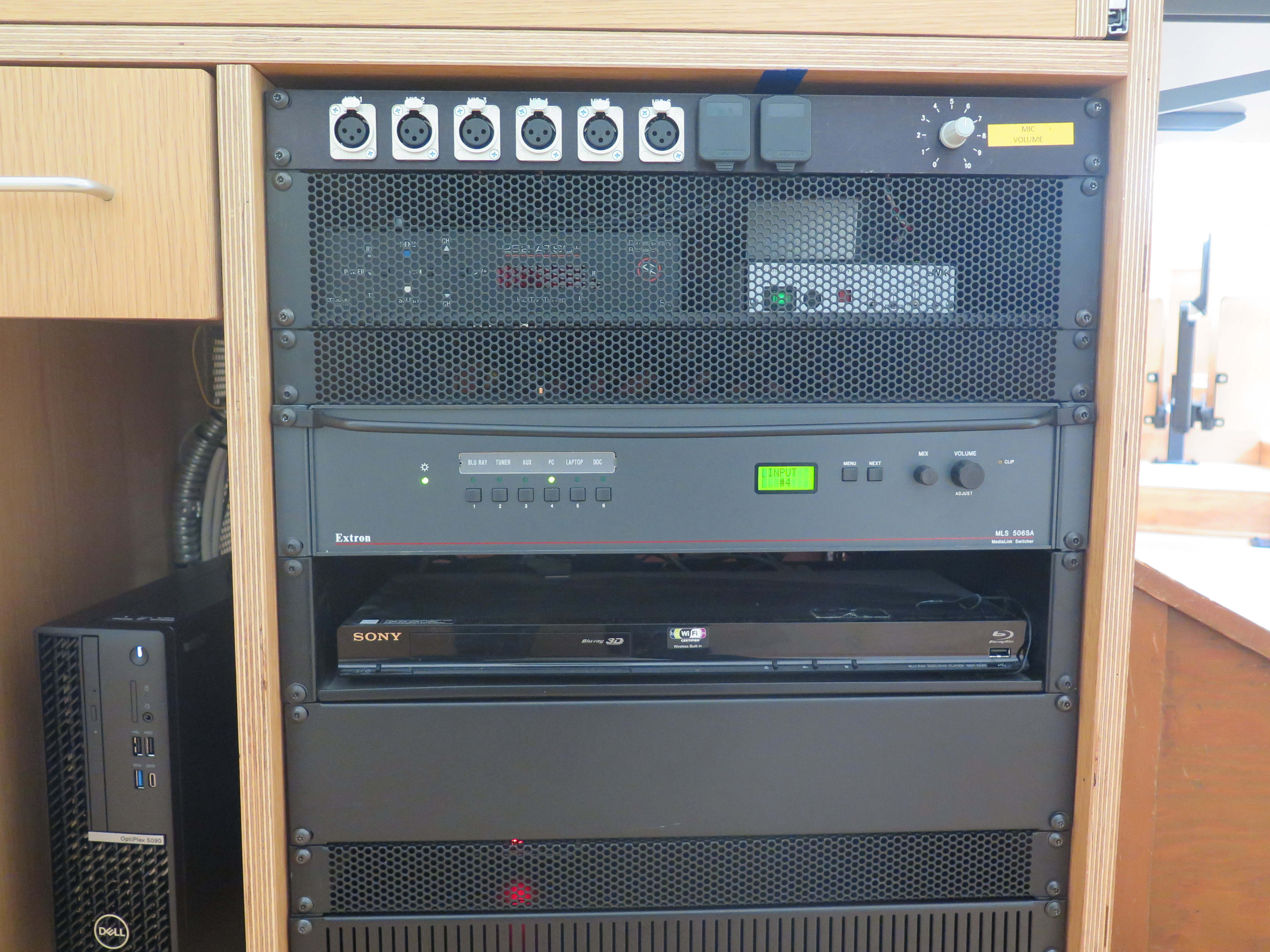 Front of Equipment rack showing Microphone volume, AV Switcher. Below that is Blue-Ray/DVD Player. To the left is the compartment with the Dell Computer CPU.