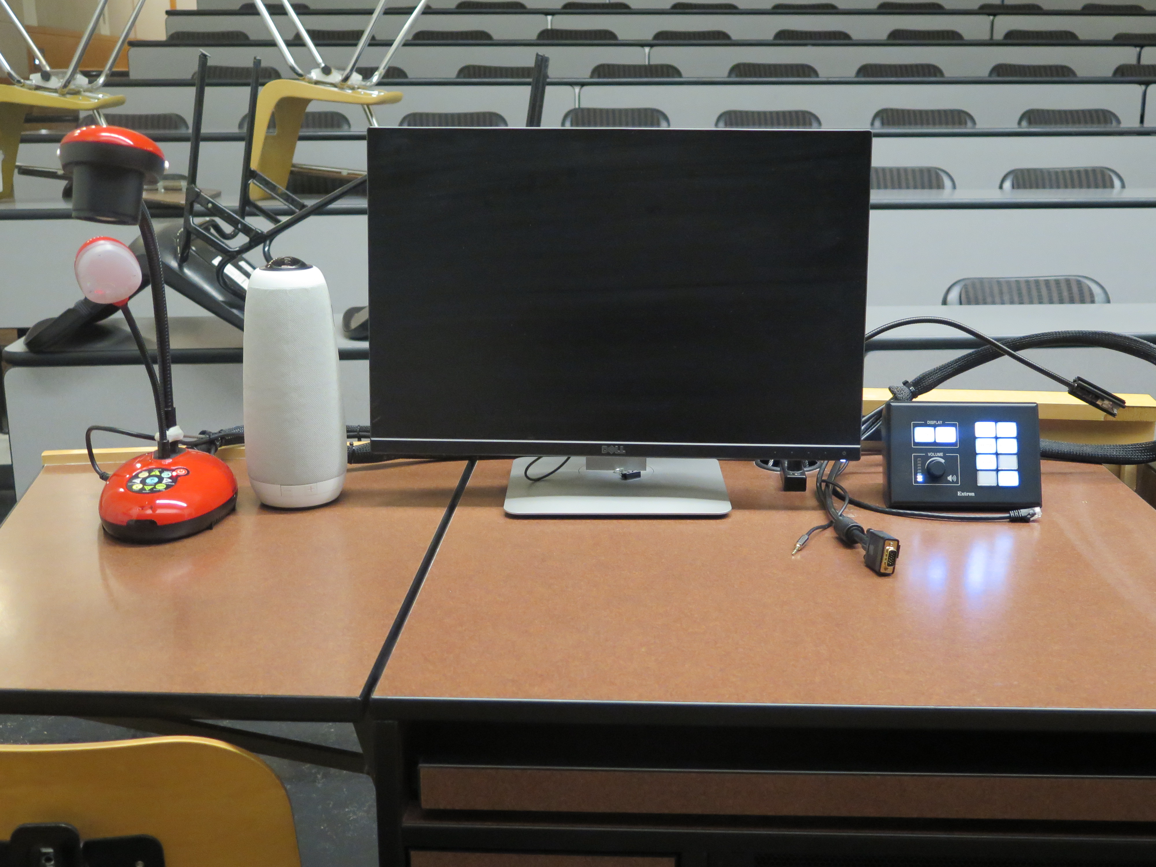 On top of Podium is Owl Camera, Dell Computer Monitor, AV Push Button Controller, and Lumens Ladybug Document Camera.