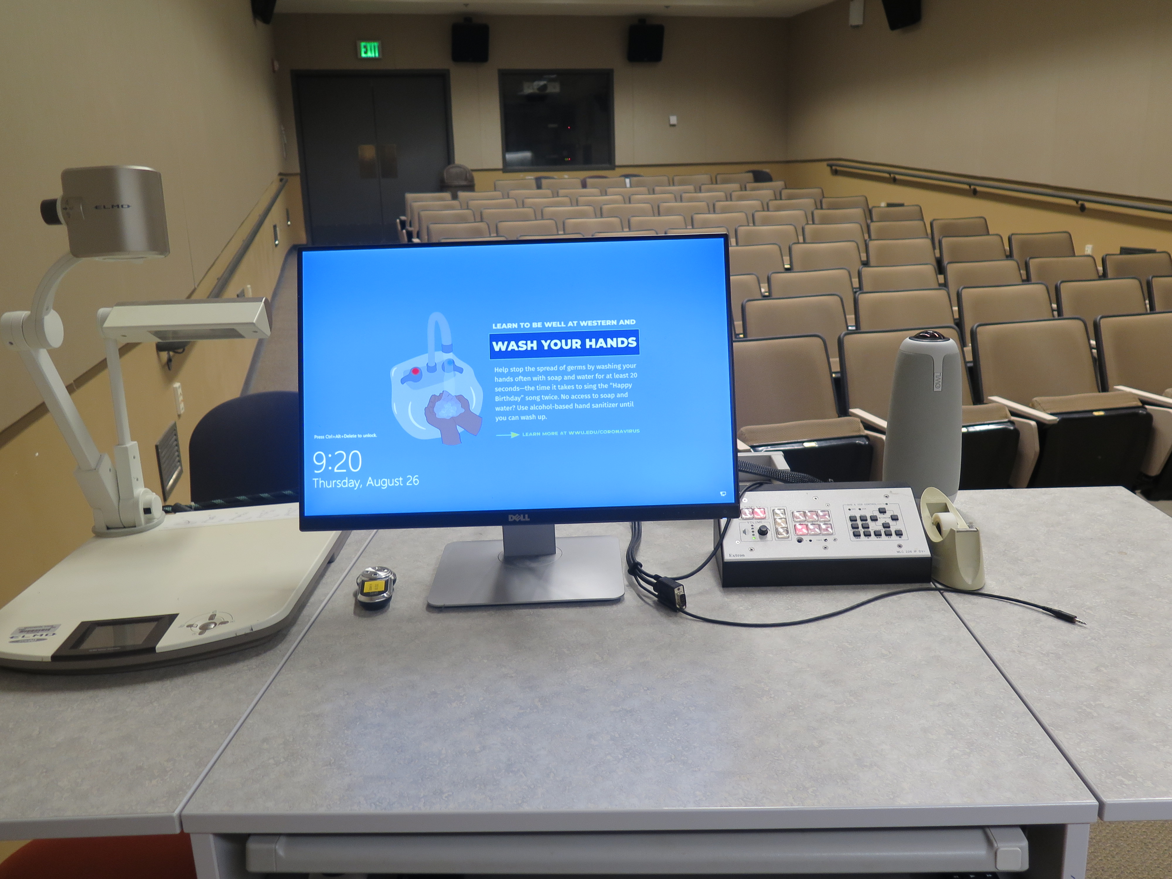 On top of Podium is Owl webcam, Dell Computer Monitor, AV Push Button Controller, and Elmo Document Camera.