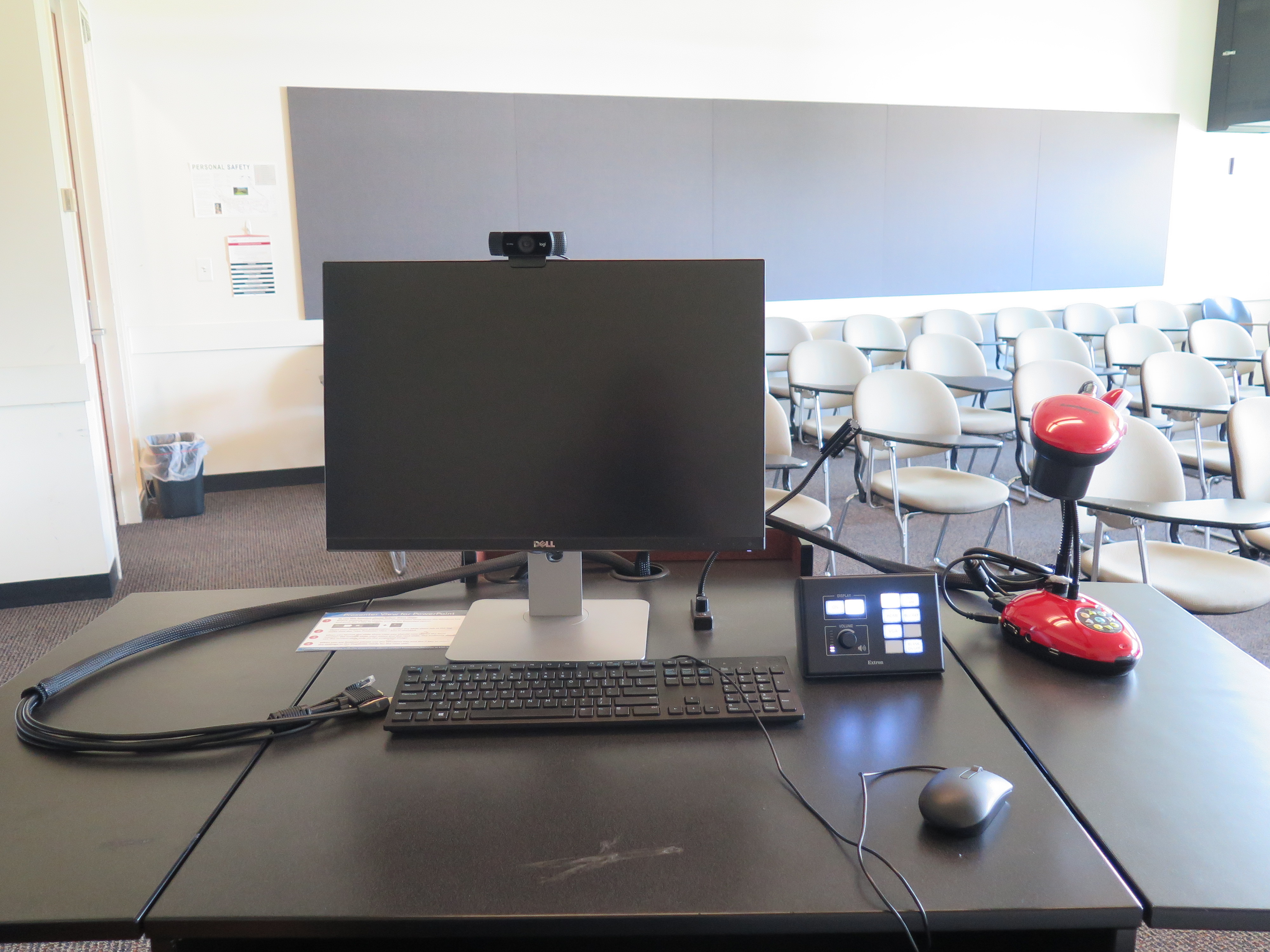On top of podium is Logitech 920 webcam, Dell computer monitor, AV push button controller, and Lumens Ladybug document camera.