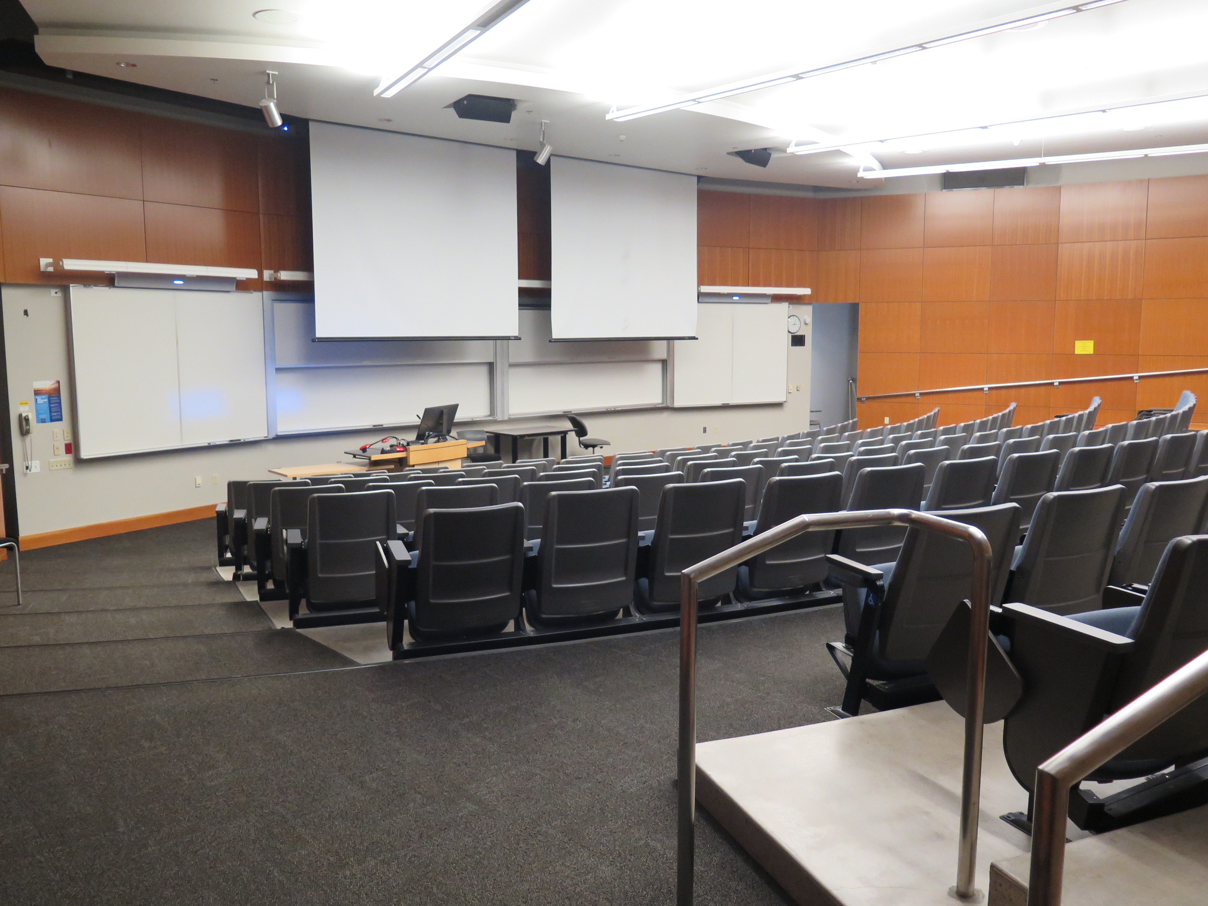 Lecture Hall consists of auditorium style, stationary tablet armchairs, White board and podium are located at the front of the room.