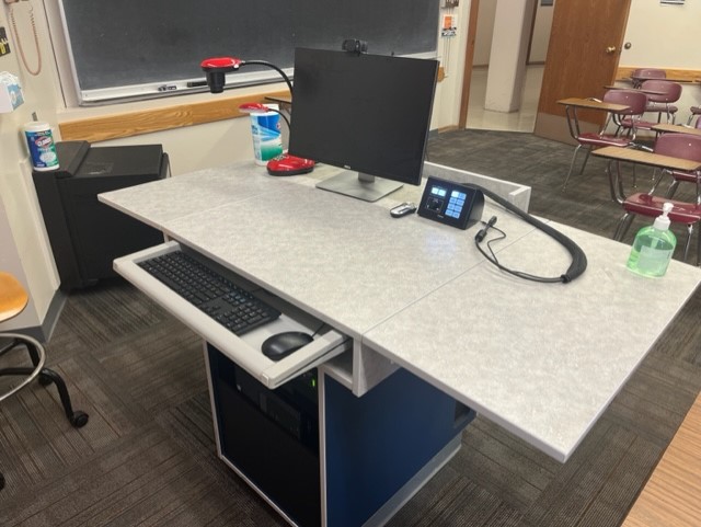 Top of teaching podium showing Document camera, control box, keyboard, mouse, computer monitor