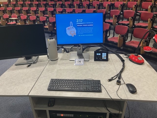Top of teaching podium showing Document camera, control box, Owl camera, keyboard, mouse, computer monitor